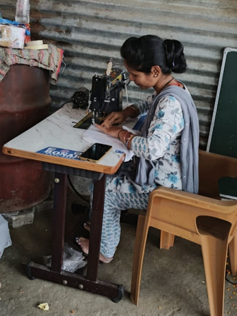 Woman learning tailoring skills through SAANJ women empowerment program